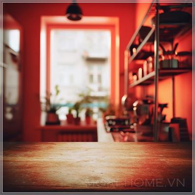 The foreground is the desktop, the red blurred kitchen background, and the light is bright....